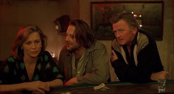 Movie still from “Barfly” (1987), directed by Barbet Schroeder – A group of people sitting at a table; Medium shot, Low angle