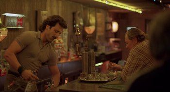 Movie still from “Barfly” (1987), directed by Barbet Schroeder – A man and a woman at a bar; Medium shot, Over the shoulder angle