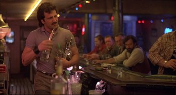 Movie still from “Barfly” (1987), directed by Barbet Schroeder – A group of men sitting at a bar with drinks; Medium shot, Low angle