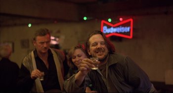 Movie still from “Barfly” (1987), directed by Barbet Schroeder – A group of people sitting at a bar drinking beer; Medium shot, Low angle