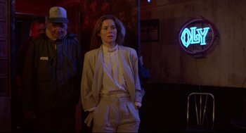 Movie still from “Barfly” (1987), directed by Barbet Schroeder – A woman standing in front of a neon sign; Medium shot, Low angle