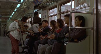 Movie still from “Barking Dogs Never Bite” (2000), directed by Bong Joon Ho – A group of people sitting on a bus reading newspapers; Wide shot, High angle