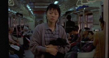 Movie still from “Barking Dogs Never Bite” (2000), directed by Bong Joon Ho – A woman holding a black cat in her arms; Medium shot, Over the shoulder angle