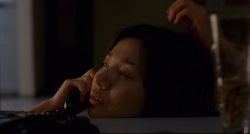 Movie still from “Barking Dogs Never Bite” (2000), directed by Bong Joon Ho – A young woman talking on a cell phone while lying down; Close Up shot, High angle