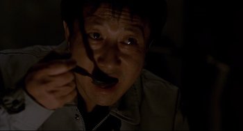 Movie still from “Barking Dogs Never Bite” (2000), directed by Bong Joon Ho – A man is holding a spoon in his mouth; Close Up shot, High angle