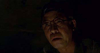 Movie still from “Barking Dogs Never Bite” (2000), directed by Bong Joon Ho – An older man wearing glasses and a hat; Close Up shot, Over the shoulder angle