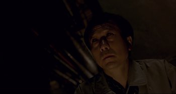 Movie still from “Barking Dogs Never Bite” (2000), directed by Bong Joon Ho – A man with a hat looking up at the ceiling; Close Up shot, Low angle