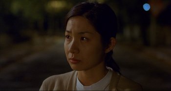 Movie still from “Barking Dogs Never Bite” (2000), directed by Bong Joon Ho – A young woman with long dark hair wearing a white t - shirt; Close Up shot, High angle