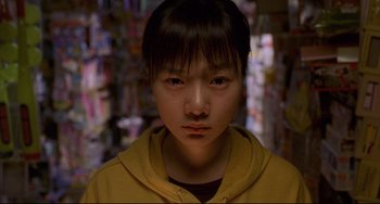Movie still from “Barking Dogs Never Bite” (2000), directed by Bong Joon Ho – A young asian boy in a yellow hoodie; Close Up shot, Low angle