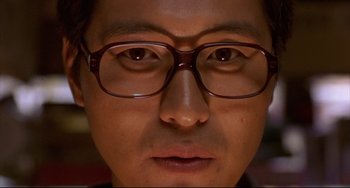 Movie still from “Barking Dogs Never Bite” (2000), directed by Bong Joon Ho – A person wearing glasses; Extreme Close Up shot, Overhead angle
