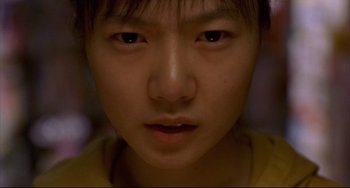 Movie still from “Barking Dogs Never Bite” (2000), directed by Bong Joon Ho – A young person's face; Extreme Close Up shot, Low angle
