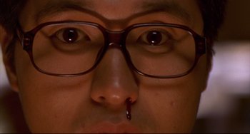 Movie still from “Barking Dogs Never Bite” (2000), directed by Bong Joon Ho – A person wearing glasses and a nose ring; Extreme Close Up shot, Overhead angle