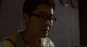 Movie still from “Barking Dogs Never Bite” (2000), directed by Bong Joon Ho – A man wearing glasses looking at the camera; Close Up shot, Low angle