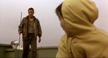 Movie still from “Barking Dogs Never Bite” (2000), directed by Bong Joon Ho – A man standing next to a young child; Medium shot, Low angle