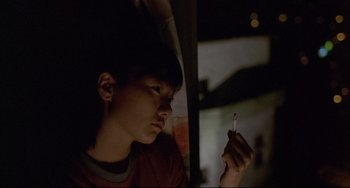Movie still from “Barking Dogs Never Bite” (2000), directed by Bong Joon Ho – A young man holding a cigarette in his hand; Close Up shot, High angle