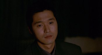 Movie still from “Barking Dogs Never Bite” (2000), directed by Bong Joon Ho – A person wearing a suit and tie; Close Up shot, High angle