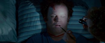 Movie still from “Step Brothers” (2008), directed by Adam McKay – A man is laying in bed with a knife in his mouth; Close Up shot, Overhead angle