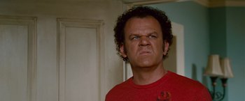 Movie still from “Step Brothers” (2008), directed by Adam McKay – A man in a red t - shirt is looking at the camera; Close Up shot, Low angle