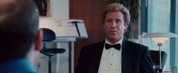 Movie still from “Step Brothers” (2008), directed by Adam McKay – A person wearing a suit and bow tie; Medium shot, Over the shoulder angle