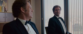 Movie still from “Step Brothers” (2008), directed by Adam McKay – Two men in tuxedos looking at each other in front of a window; Medium shot, Over the shoulder angle