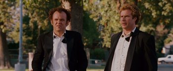 Movie still from “Step Brothers” (2008), directed by Adam McKay – Two men in suits standing next to each other in a park; Medium shot, Low angle