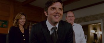 Movie still from “Step Brothers” (2008), directed by Adam McKay – A man in a suit and tie smiling for the camera; Close Up shot, Over the shoulder angle