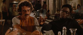 Movie still from “Barney's Version” (2010), directed by Richard J. Lewis – A man sitting at a table holding a wine glass; Medium shot, Over the shoulder angle