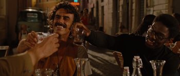 Movie still from “Barney's Version” (2010), directed by Richard J. Lewis – A man sitting at a table with a drink in his hand; Medium shot, Over the shoulder angle