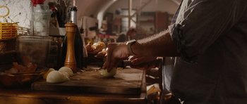 Movie still from “Barney's Version” (2010), directed by Richard J. Lewis – A person is cutting onions on a cutting board; Close Up shot, Low angle