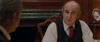 Movie still from “Barney's Version” (2010), directed by Richard J. Lewis – An older man sitting in a chair wearing a vest and tie; Close Up shot, Over the shoulder angle