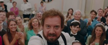 Movie still from “Barney's Version” (2010), directed by Richard J. Lewis – A group of people sitting in front of a man with a beard; Close Up shot, Over the shoulder angle