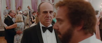 Movie still from “Barney's Version” (2010), directed by Richard J. Lewis – A man in a tuxedo and bow tie looking at another man in a suit; Close Up shot, Over the shoulder angle