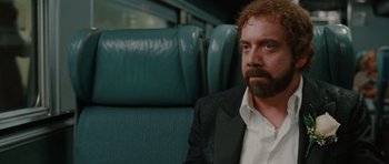 Movie still from “Barney's Version” (2010), directed by Richard J. Lewis – A man sitting on a seat on a train; Close Up shot, Over the shoulder angle