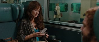 Movie still from “Barney's Version” (2010), directed by Richard J. Lewis – A woman sitting on a train looking at a book; Medium shot, Over the shoulder angle