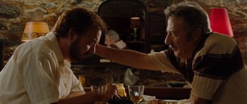 Movie still from “Barney's Version” (2010), directed by Richard J. Lewis – Two men sitting at a dinner table with drinks; Medium shot, Over the shoulder angle