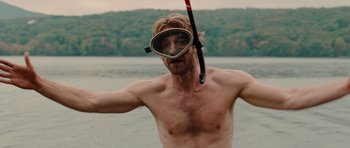 Movie still from “Barney's Version” (2010), directed by Richard J. Lewis – A shirtless man with a diving mask on his face; Medium shot, Over the shoulder angle
