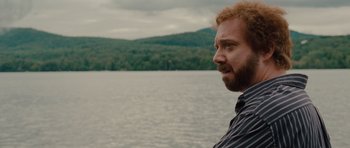 Movie still from “Barney's Version” (2010), directed by Richard J. Lewis – A man standing in front of a body of water; Close Up shot, Over the shoulder angle