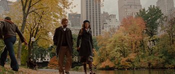 A man and a woman are walking in a park