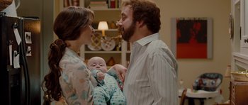 Movie still from “Barney's Version” (2010), directed by Richard J. Lewis – A man and a woman holding a baby in his arms; Medium shot, Over the shoulder angle