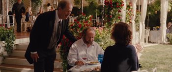 Movie still from “Barney's Version” (2010), directed by Richard J. Lewis – A man sitting at a table with a plate of food; Medium shot, Over the shoulder angle