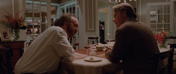 Movie still from “Barney's Version” (2010), directed by Richard J. Lewis – Two men are sitting at a table with wine; Medium shot, Over the shoulder angle
