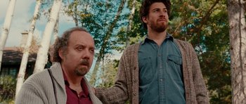 Movie still from “Barney's Version” (2010), directed by Richard J. Lewis – Two men standing next to each other near a tree; Medium shot, Low angle