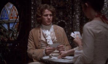 Movie still from “Barry Lyndon” (1975), directed by Stanley Kubrick – A man sitting at a table with a woman holding cards; Medium shot, Over the shoulder angle