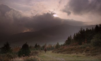 Movie still from “Barry Lyndon” (1975), directed by Stanley Kubrick – A person riding a horse on a trail in the mountains; Extreme Wide shot, Low angle