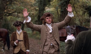 Movie still from “Barry Lyndon” (1975), directed by Stanley Kubrick – A man in a brown suit and a brown and white hat; Medium shot, Low angle