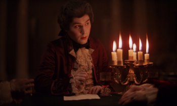 Movie still from “Barry Lyndon” (1975), directed by Stanley Kubrick – A man sitting in front of a table with lit candles; Medium shot, High angle