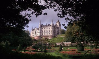 Movie still from “Barry Lyndon” (1975), directed by Stanley Kubrick – A castle like building sitting on top of a green hill; Extreme Wide shot, Low angle