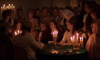 Movie still from “Barry Lyndon” (1975), directed by Stanley Kubrick – A group of people sitting around a table with lit candles; Medium shot, High angle