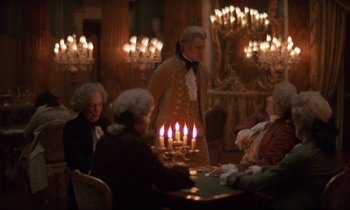 Movie still from “Barry Lyndon” (1975), directed by Stanley Kubrick – A group of people sitting around a table with lit candles on it; Medium shot, Over the shoulder angle