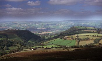 Movie still from “Barry Lyndon” (1975), directed by Stanley Kubrick – A view of a green valley with trees in the foreground; Extreme Wide shot, High angle